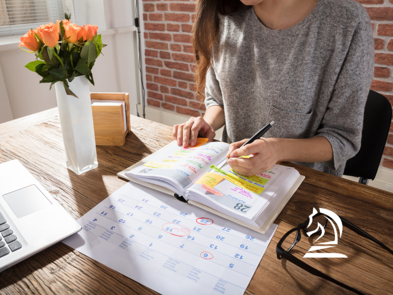 Photo of a woman working over a calendar with a highlighter